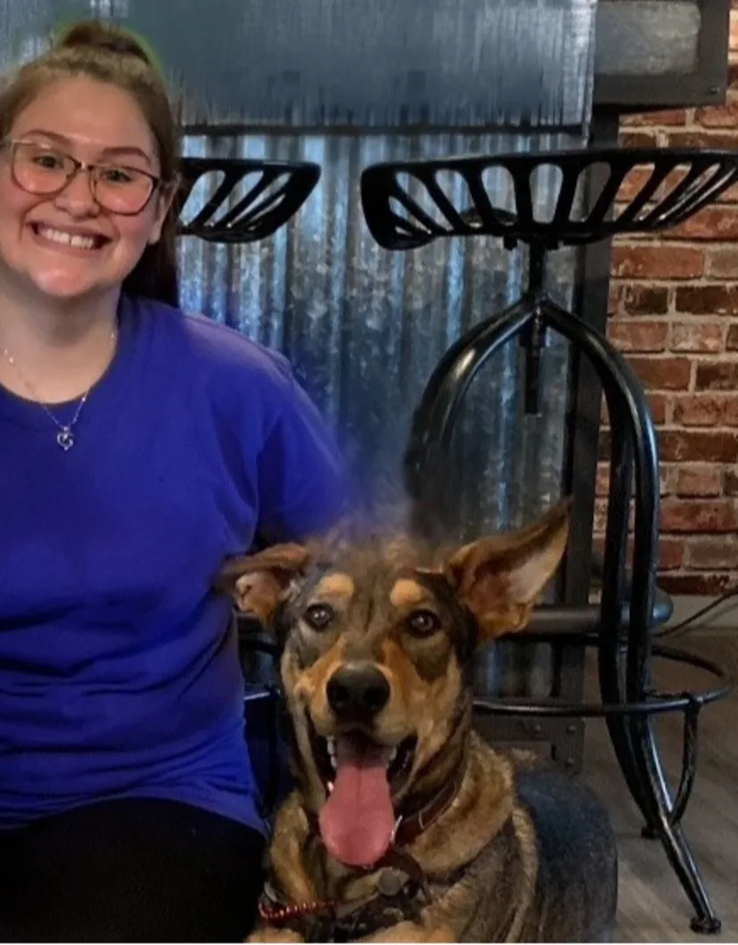 Bianca holding a black cat and sitting in a chair at Grandview Veterinary Clinic